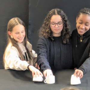 Alisa, Aëla et Mirna imaginent une scène avec des tasses à café